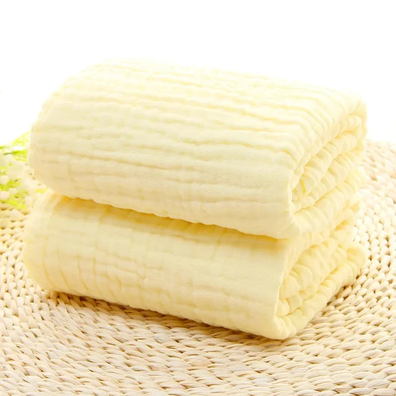 Folded beige blanket on a woven surface