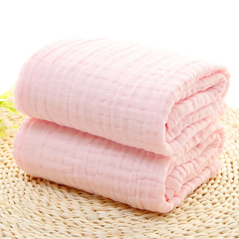 Folded pink blanket on a woven mat