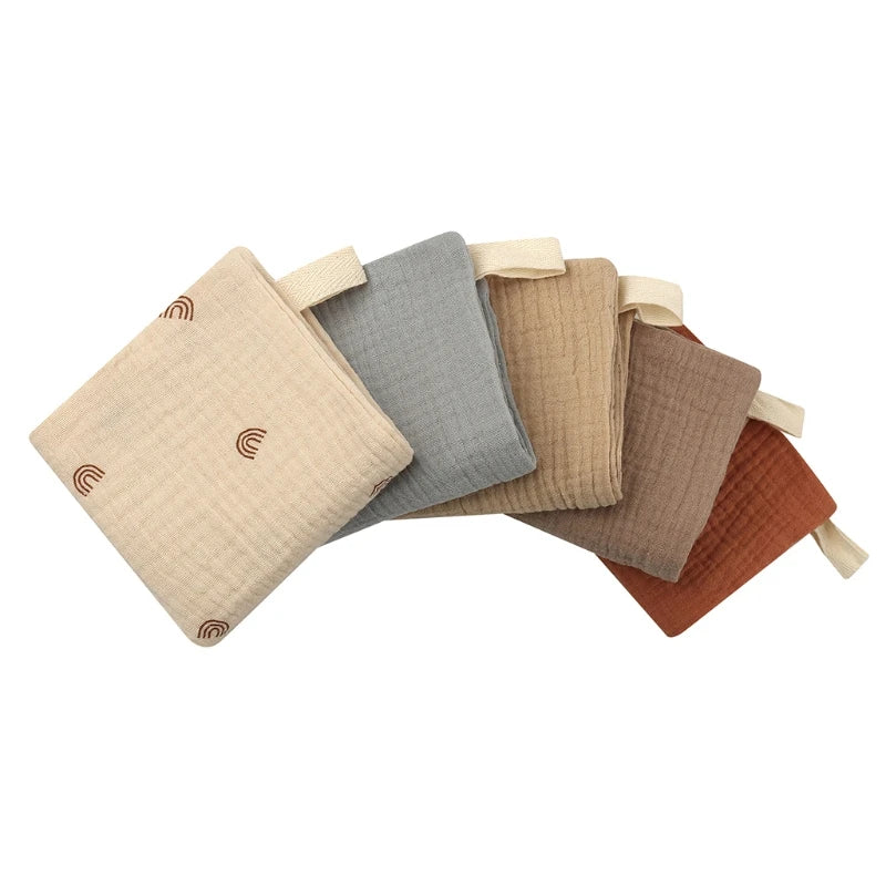 Set of five fabric swaddles in beige, gray, brown, and rust colors on a white background.