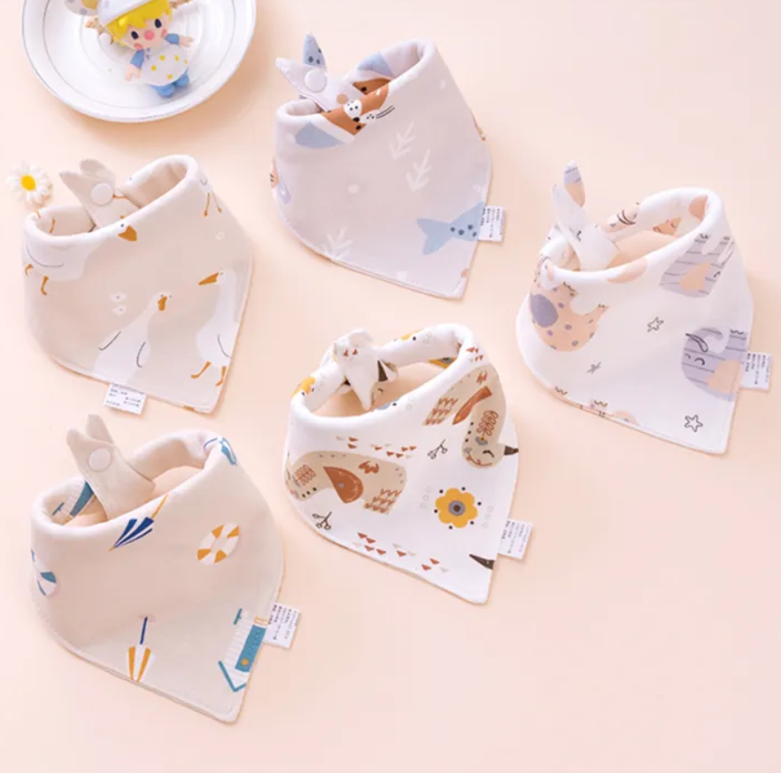 Set of baby bibs with animal prints on a light pink background