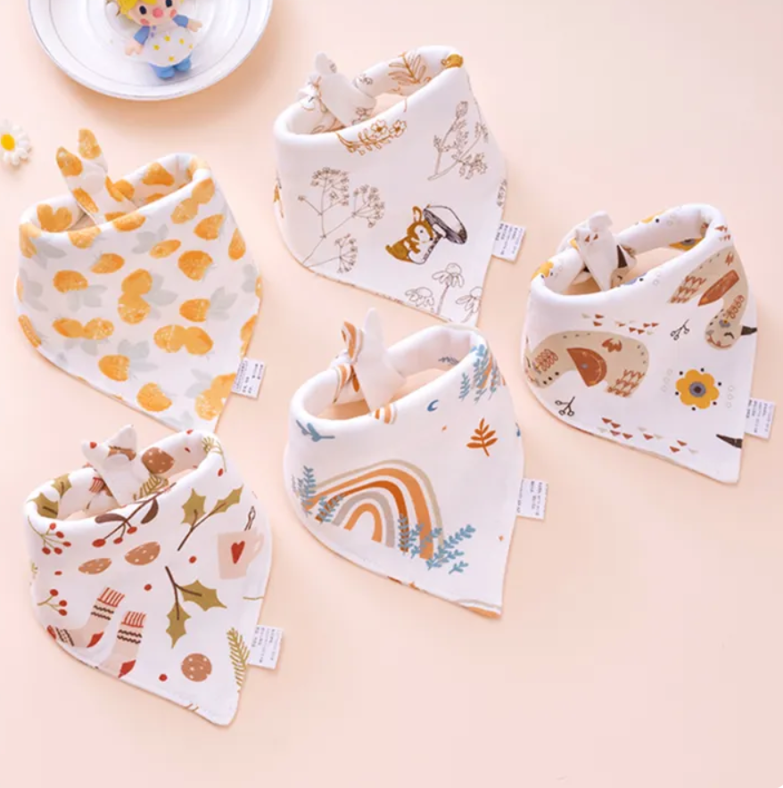 Set of baby bibs with various patterns on a light pink background