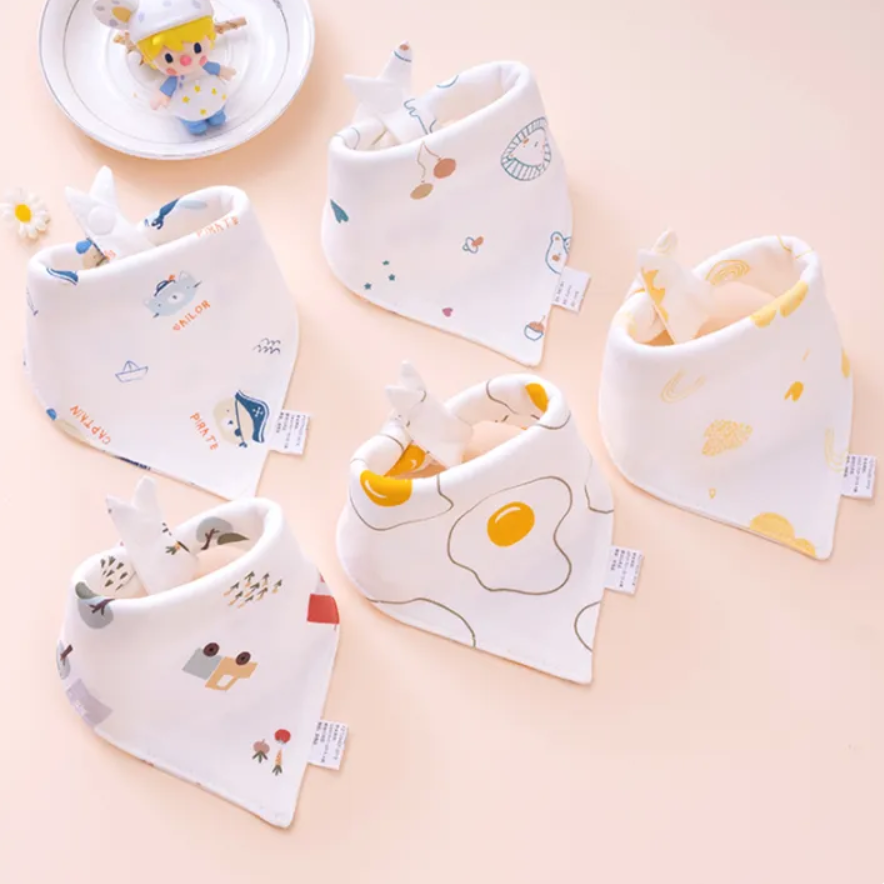 Set of baby bibs with cartoon designs on a light pink background